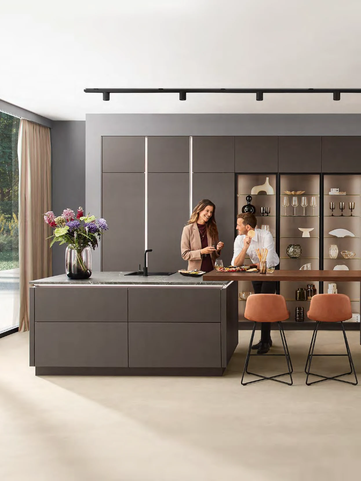 Two people using a coffee-coloured kitchen from the Kutchenhaus brochure