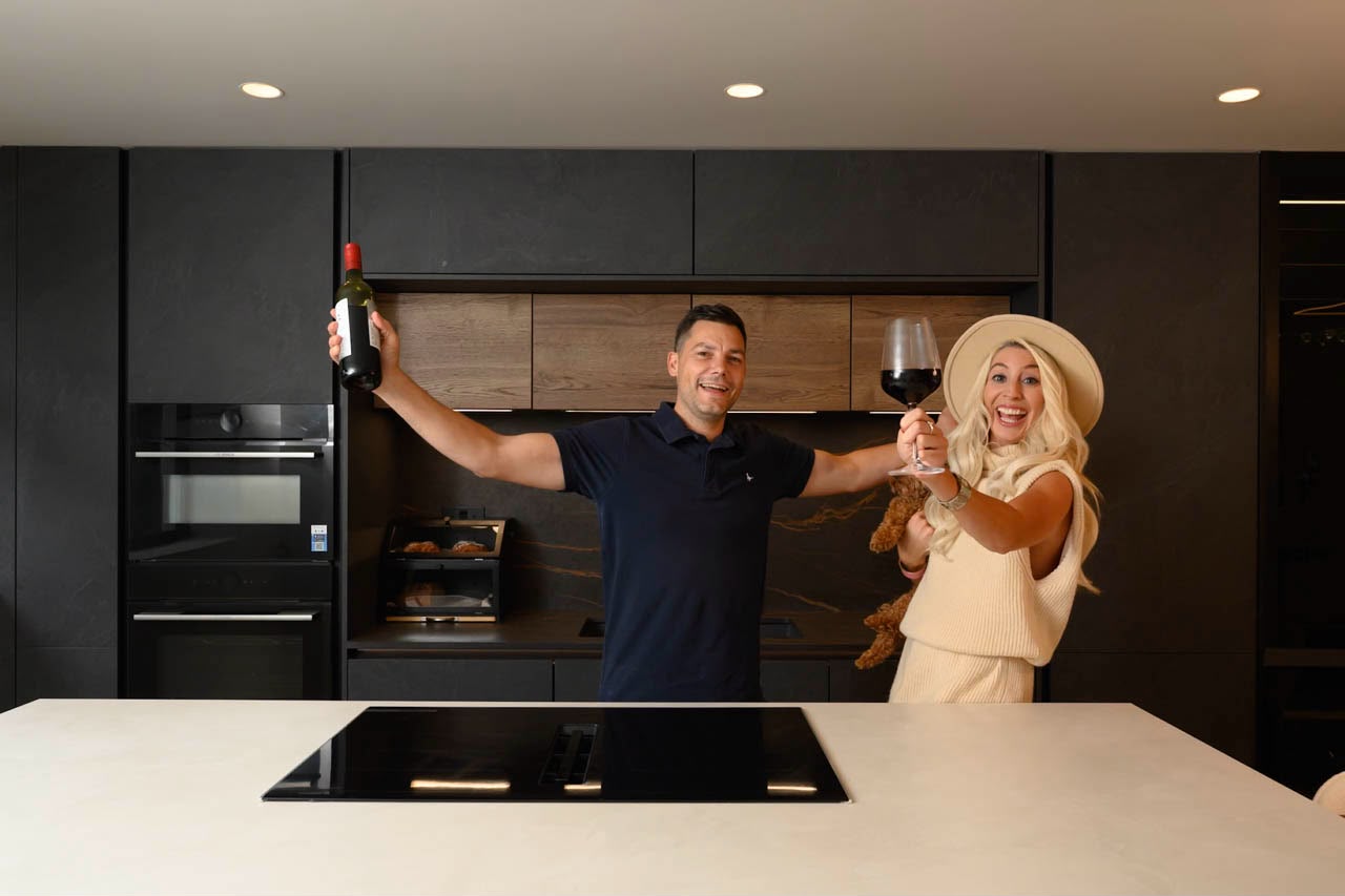 Two people celebrating with a glass of wine in the Chiswick House kitchen