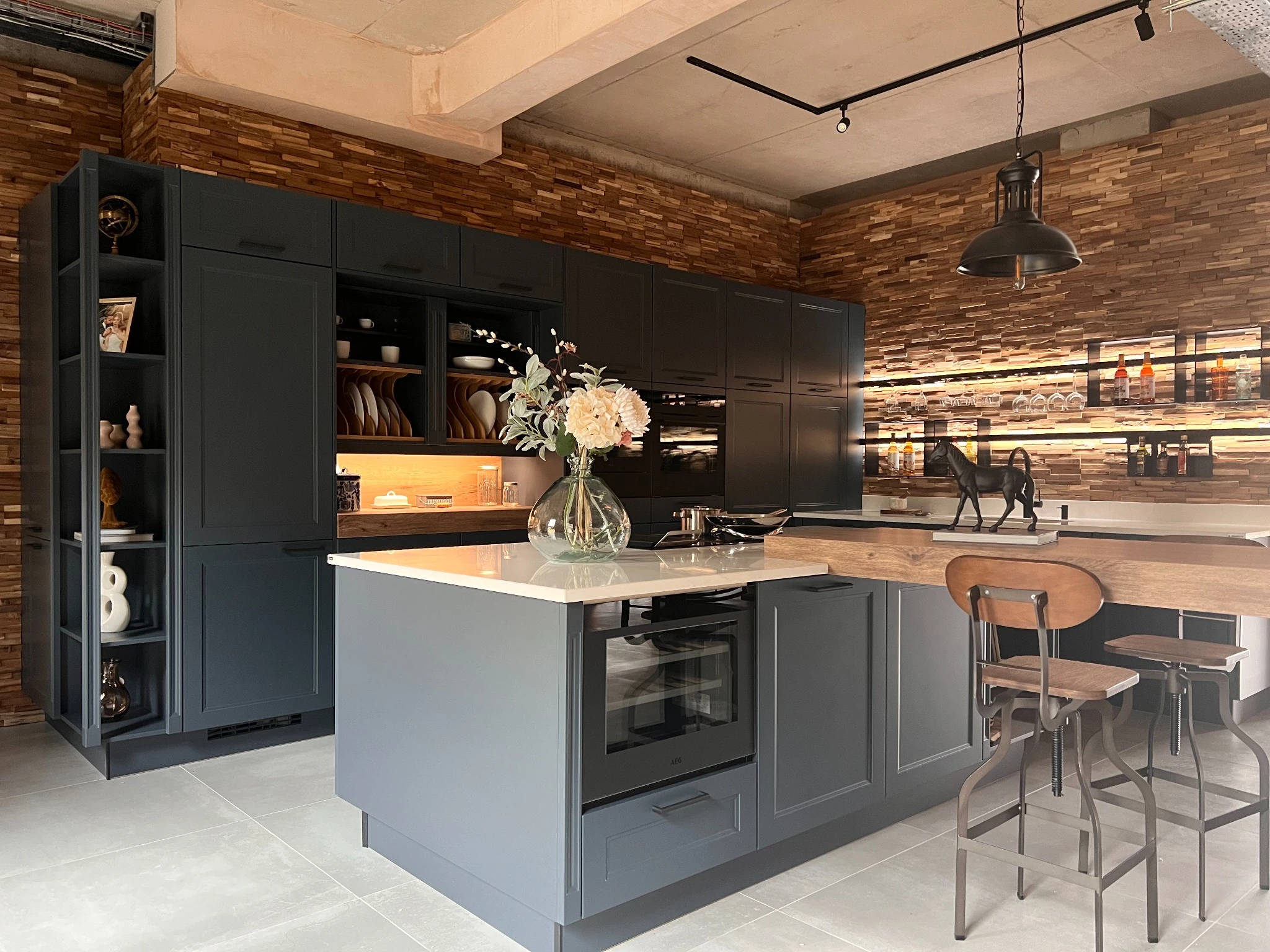 Deep blue shaker kitchen with an island, timber breakfast bar and illuminated shelving