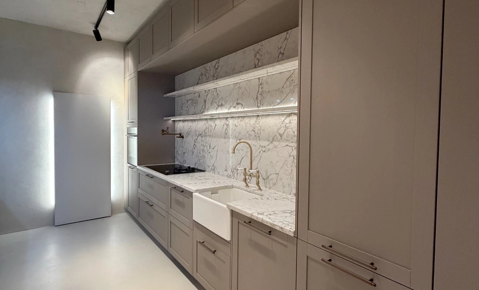 Neutral shaker kitchen with veined splashback, brass tap and Belfast sink